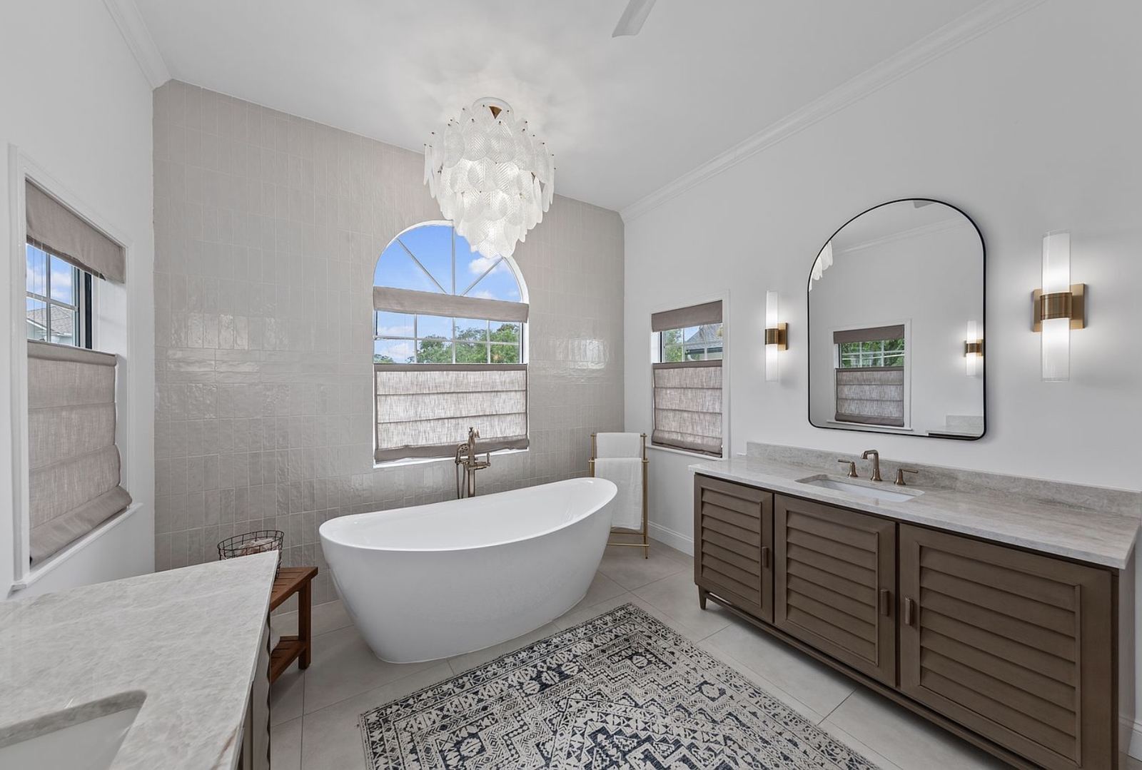 Remodeled primary bathroom with soaking tub and chandelier